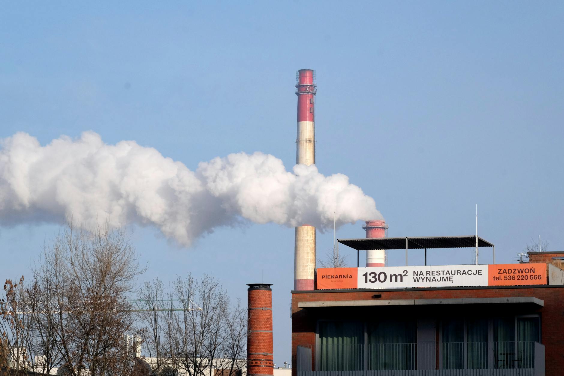 Grafika symbolizująca czyste powietrze i domy z panelami fotowoltaicznymi, z napisem "Dofinansowanie Czyste Powietrze Suwałki"